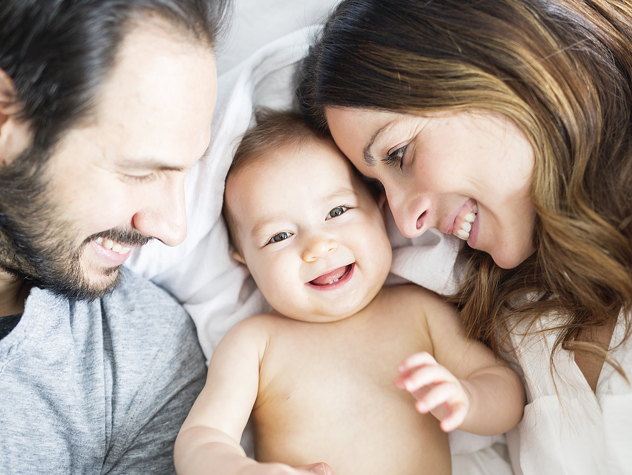 Glückliche Eltern mit lächelndem Baby Glückliche Eltern mit lächelndem Baby