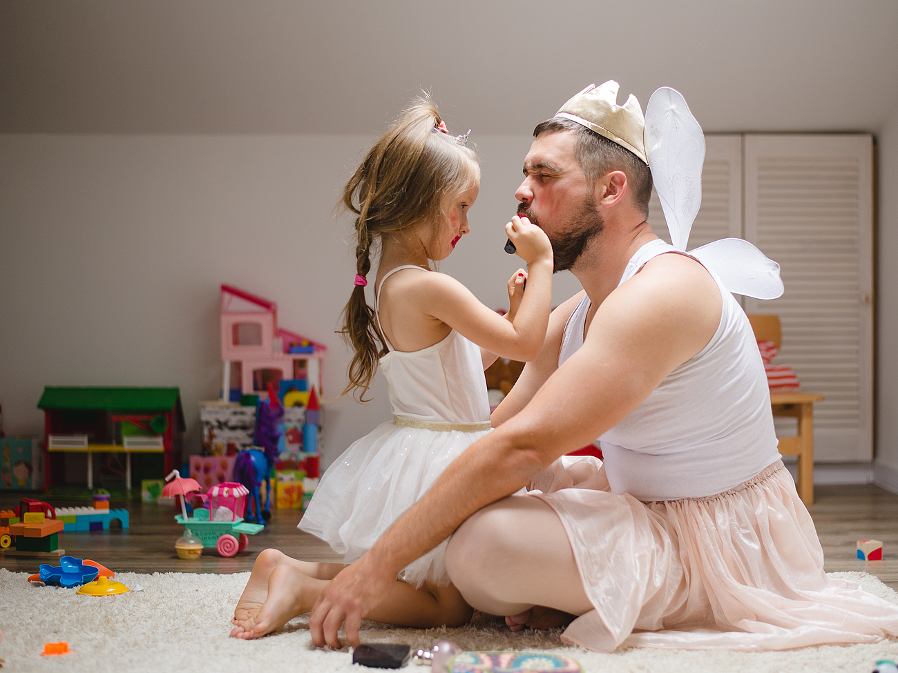 Kind mit Vater Ein Kind schminkt ihren Vater in einem Köstum